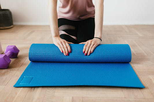 woman rolling up yoga mat